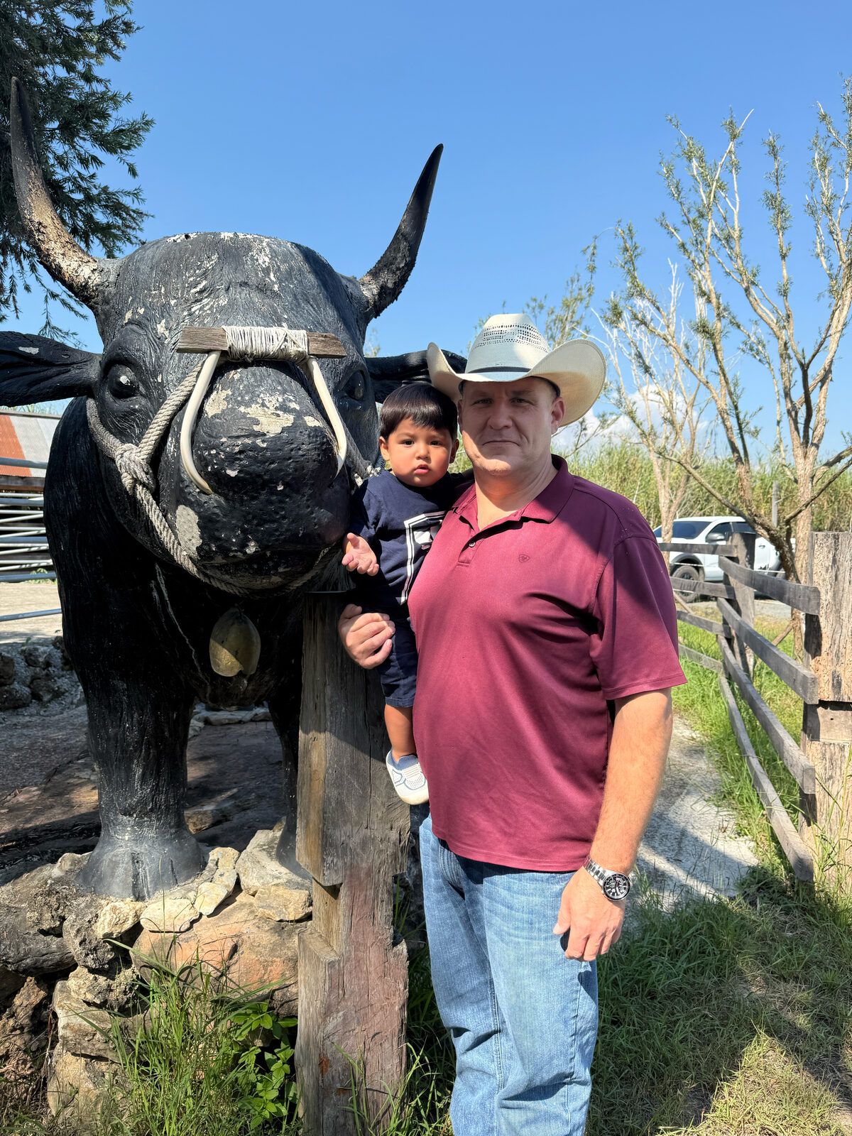 Ben Cunningham and his son at a cattle ranch entrance in Texas